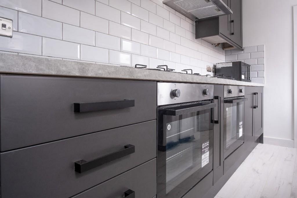 Modern kitchen featuring sleek cabinetry, ample...