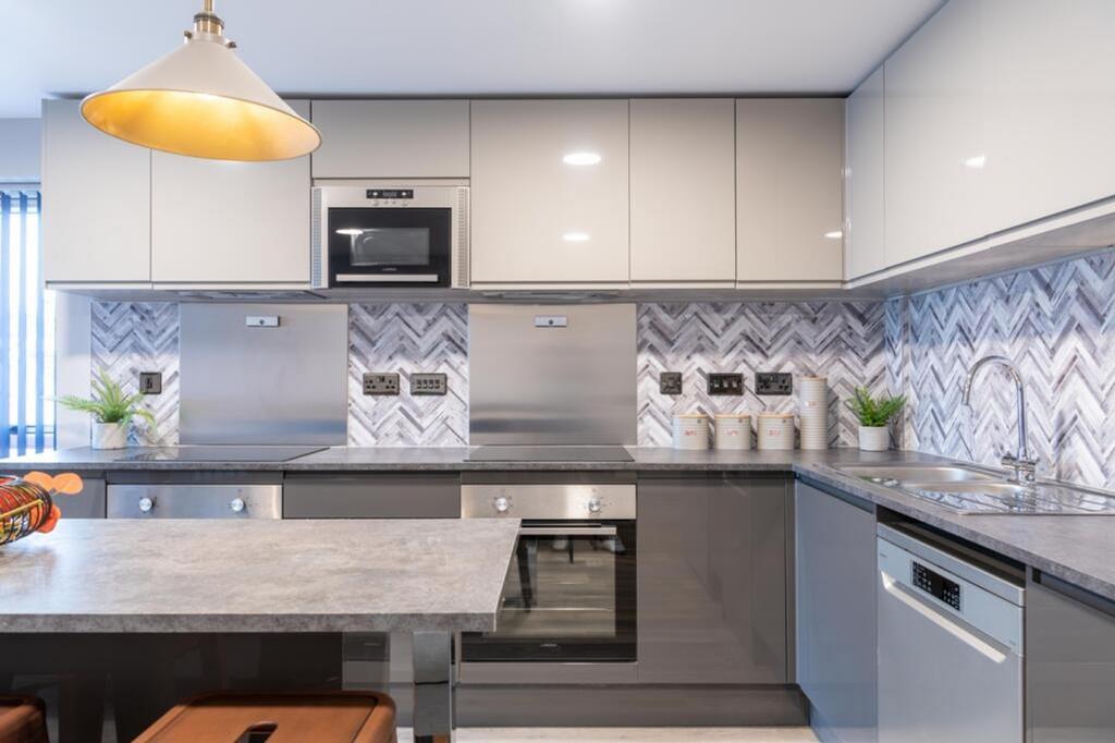 A modern and stylish kitchen featuring sleek ca...