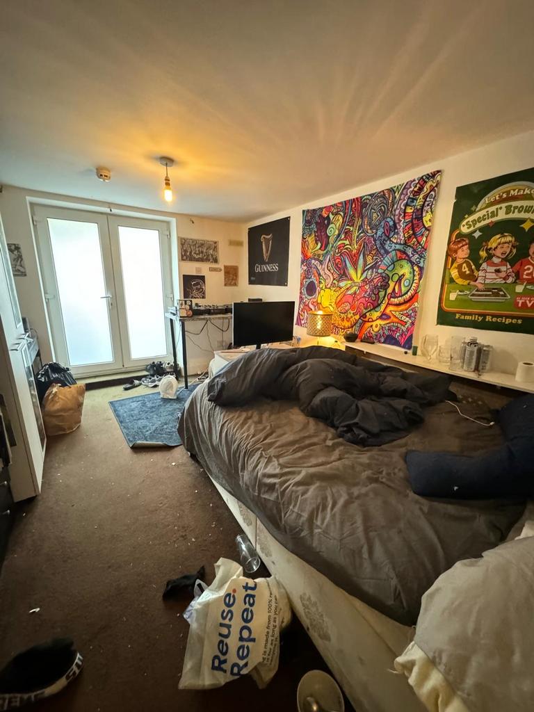 A cozy double bedroom featuring a vibrant tapes...