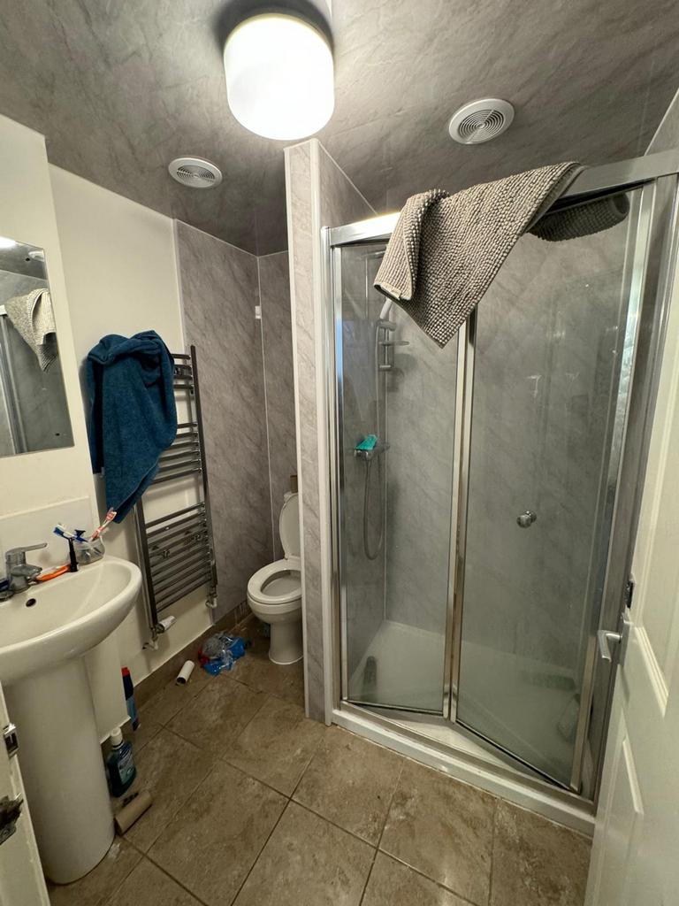 A modern bathroom featuring a spacious shower a...