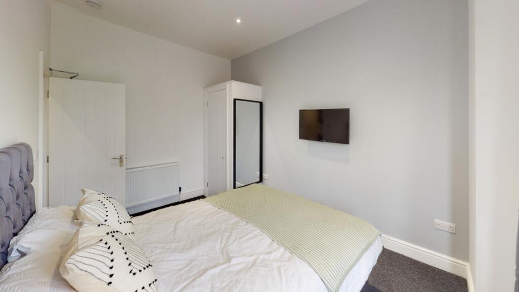 Spacious double bedroom featuring modern decor,...