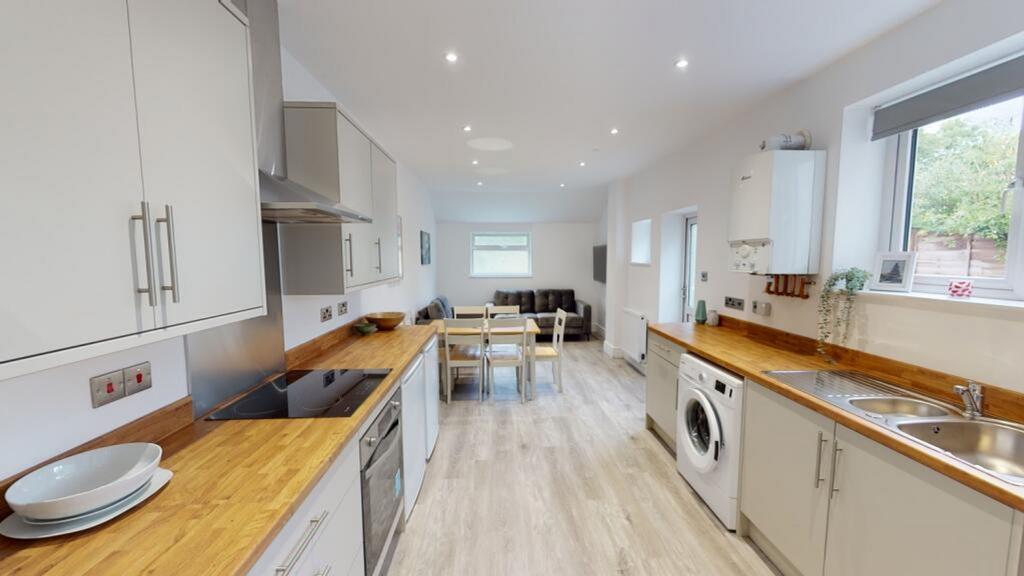 A modern kitchen featuring sleek cabinetry, a s...