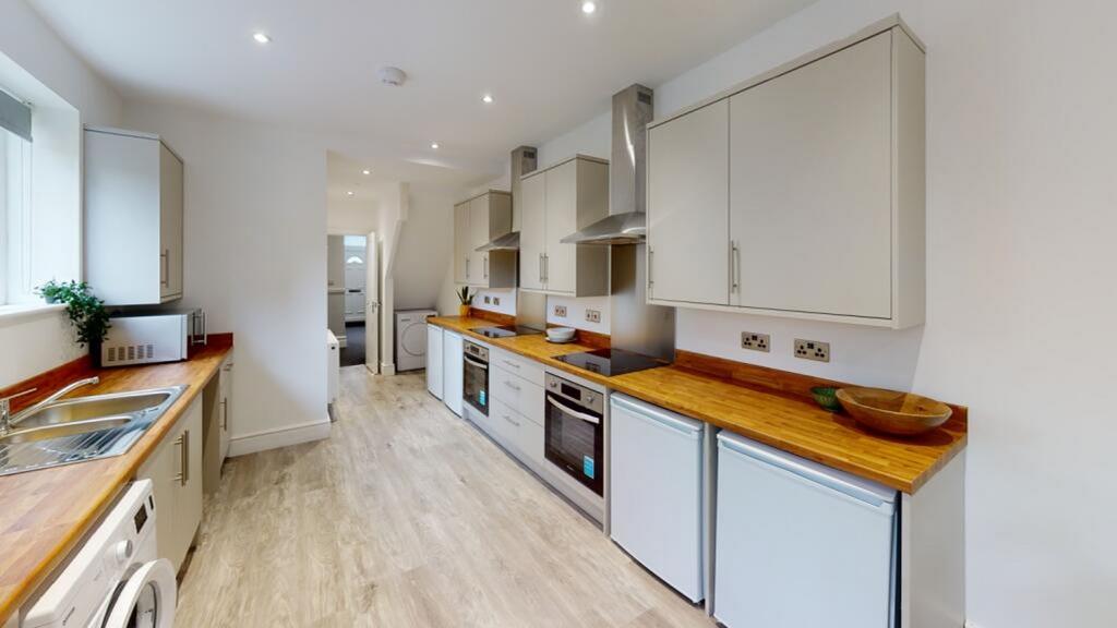 Spacious and modern kitchen featuring ample cou...