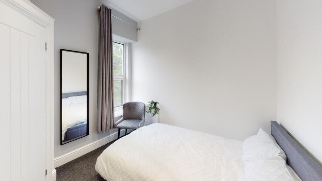 This inviting double bedroom features large win...