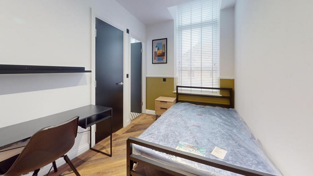 A bright and tidy single bedroom with a modern ...
