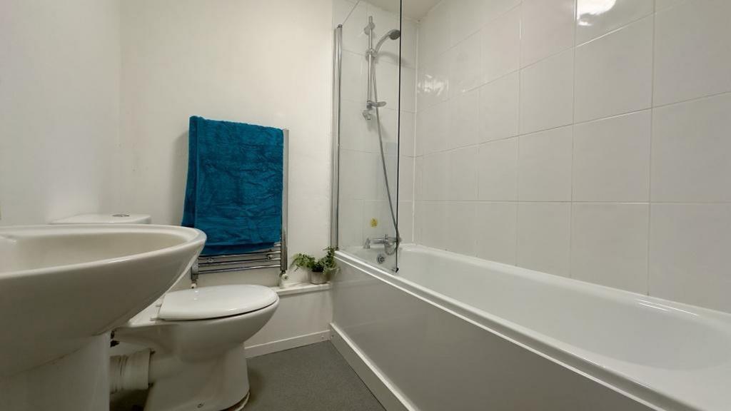 A clean and modern bathroom featuring a bath an...