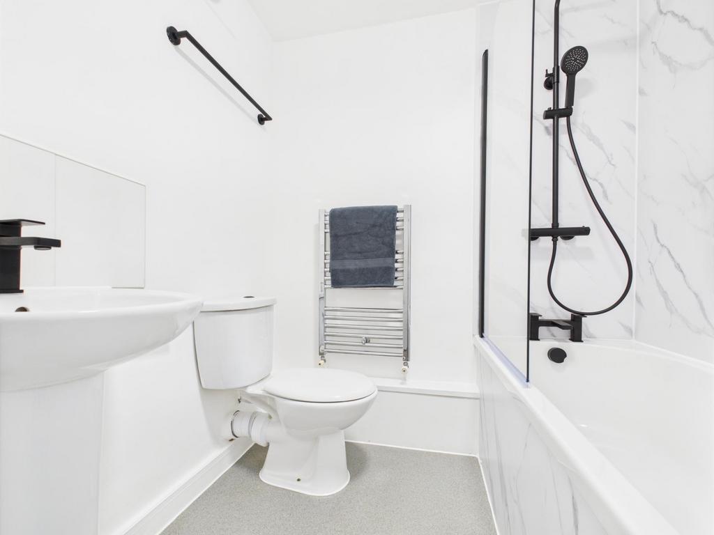 Bright modern bathroom with a white suite, bath...