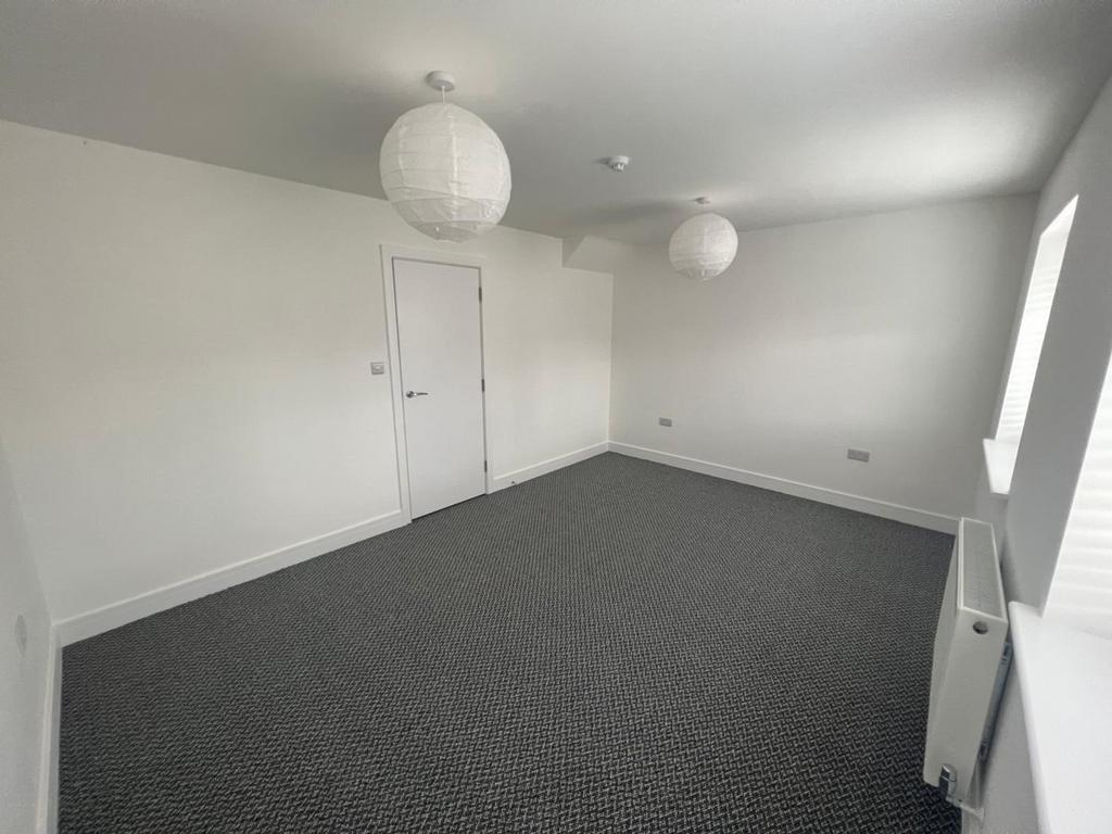 Spacious double bedroom featuring modern lighti...