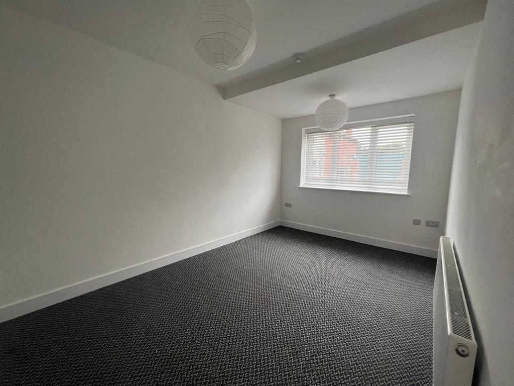 Spacious double bedroom featuring ample natural...