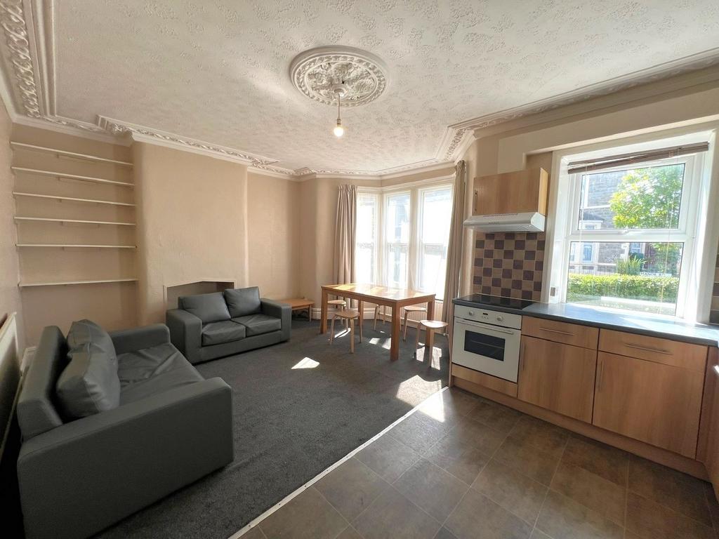 Bright open-plan living area with bay windows, ...