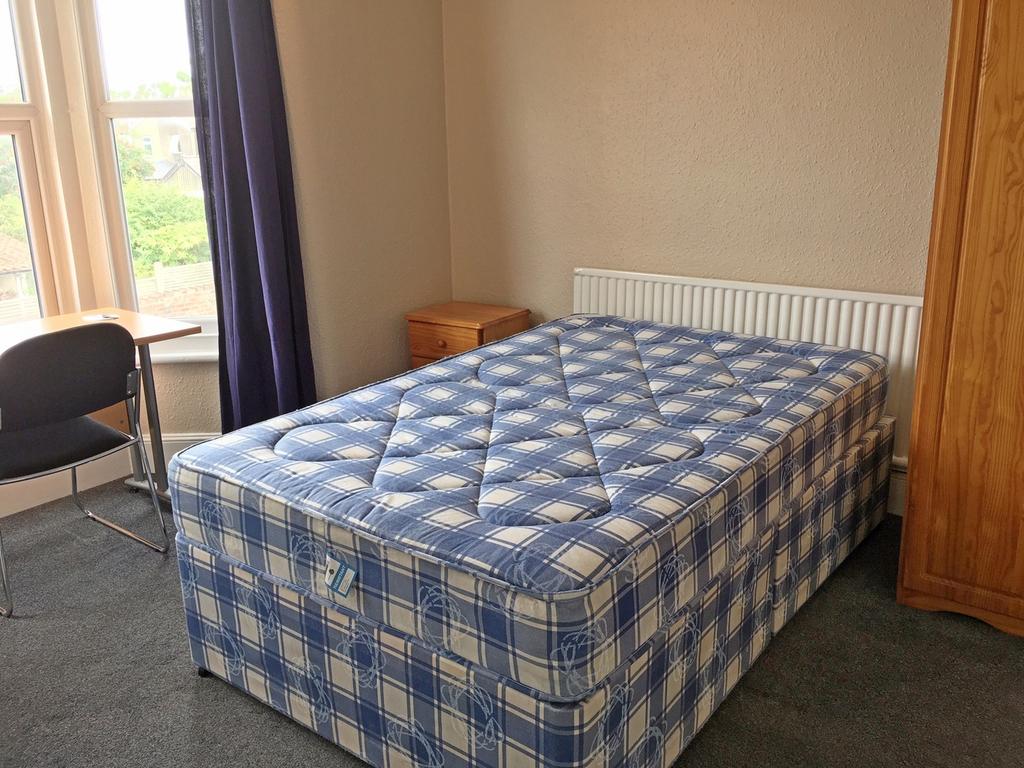 A cozy double bedroom featuring a spacious layo...