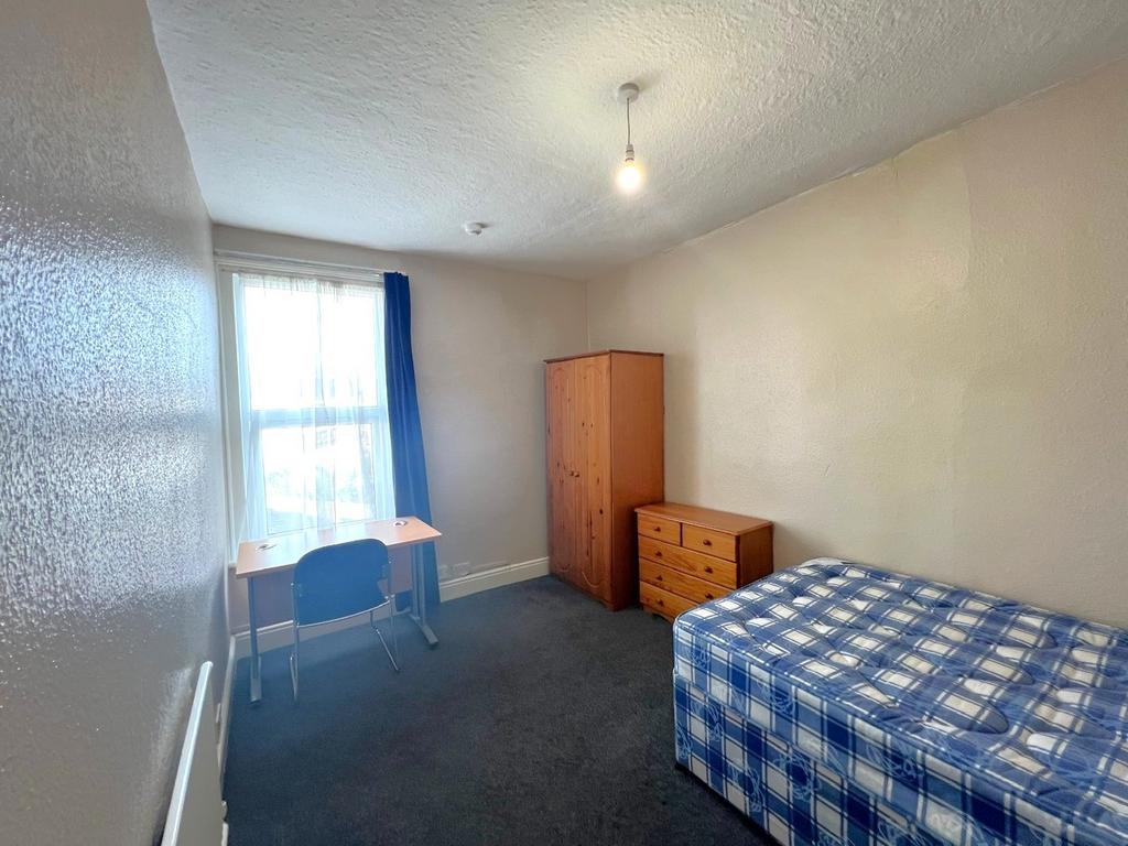 Bright single bedroom with a large window, simp...