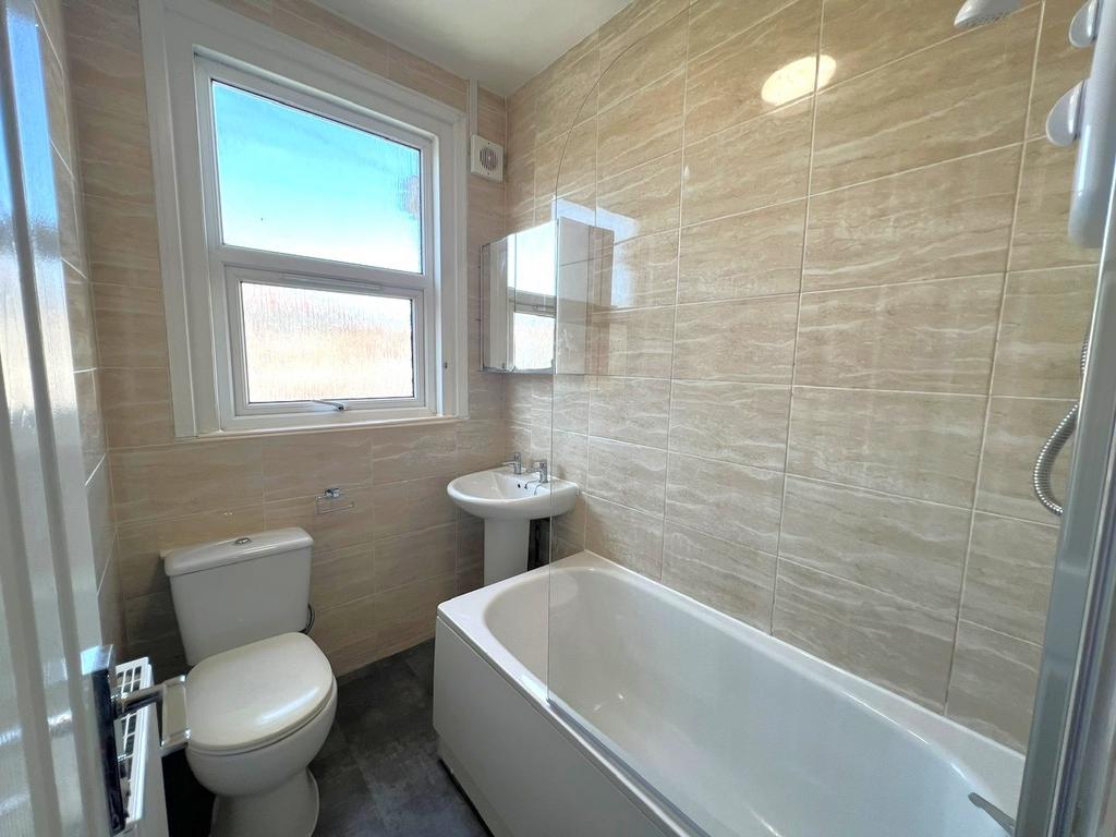 Bright, modern bathroom with a white bath and s...