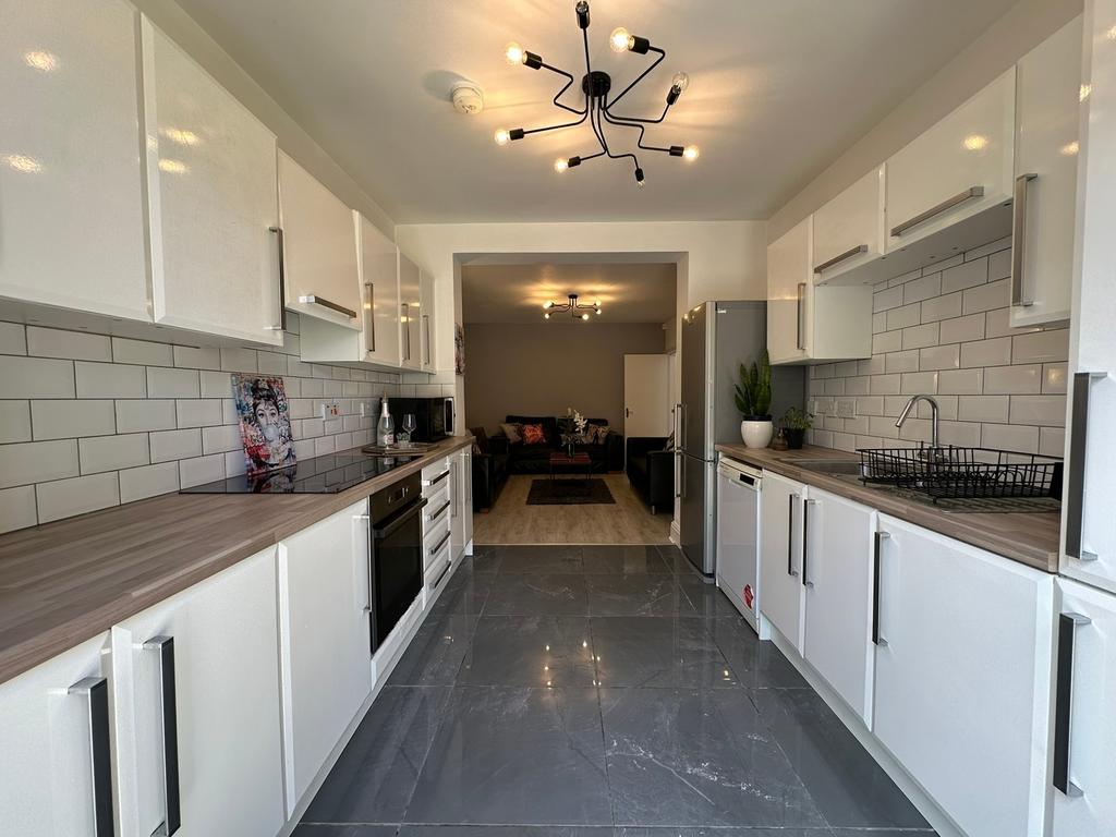 A modern kitchen featuring sleek white cabinetr...