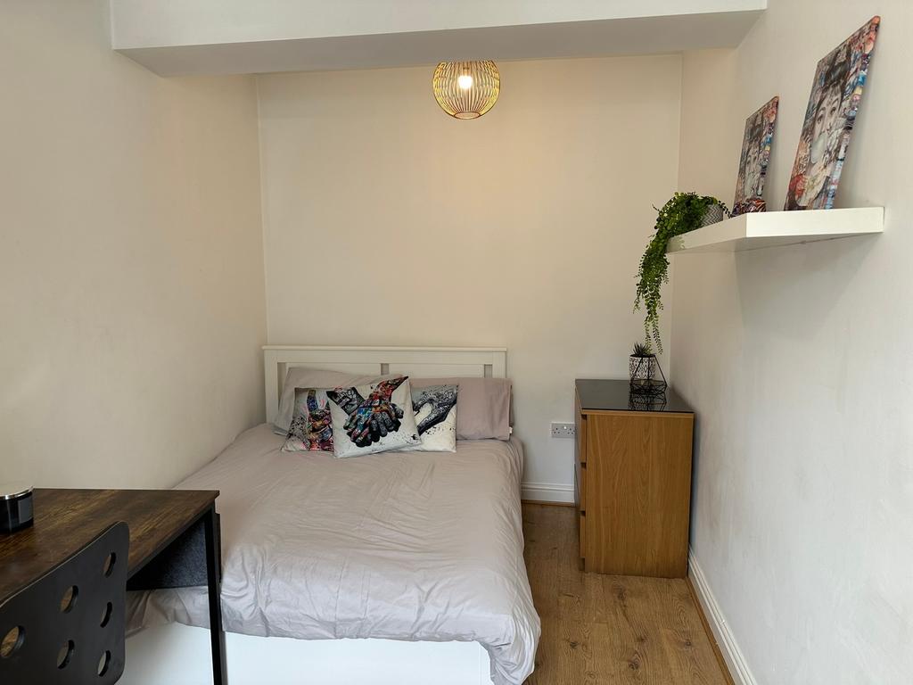 This cozy double bedroom features a comfortable...