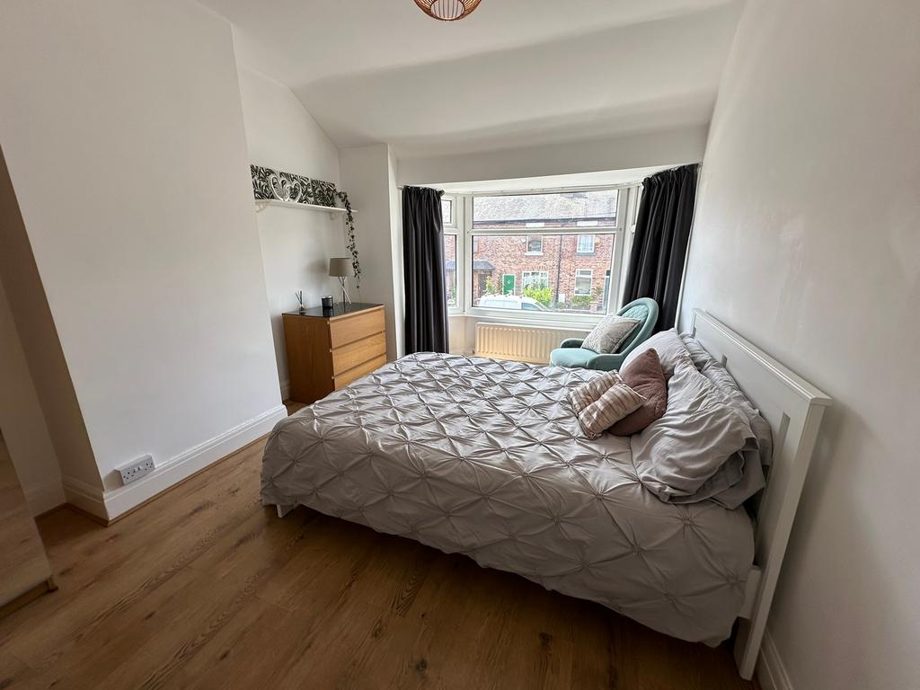 This inviting double bedroom features a comfort...