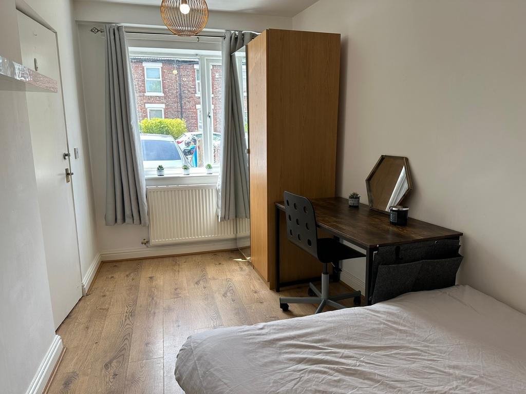 A spacious double bedroom featuring a comfortab...