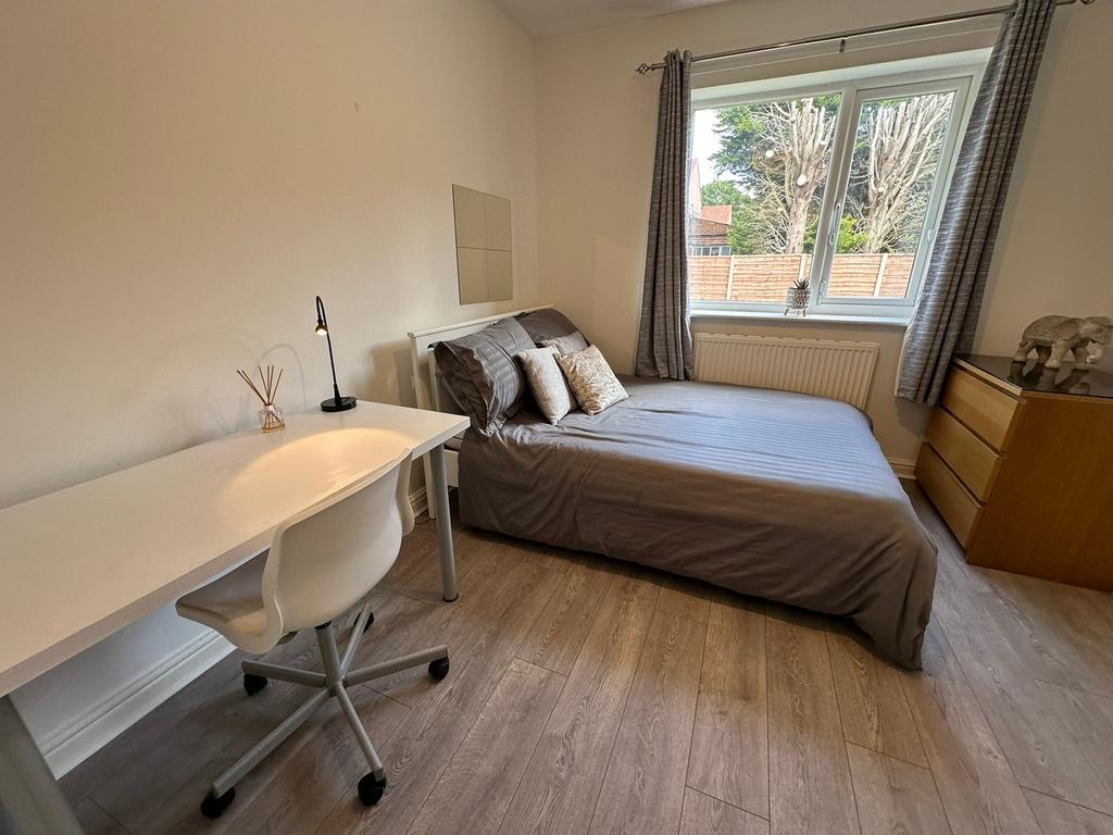 Spacious double bedroom featuring large windows...