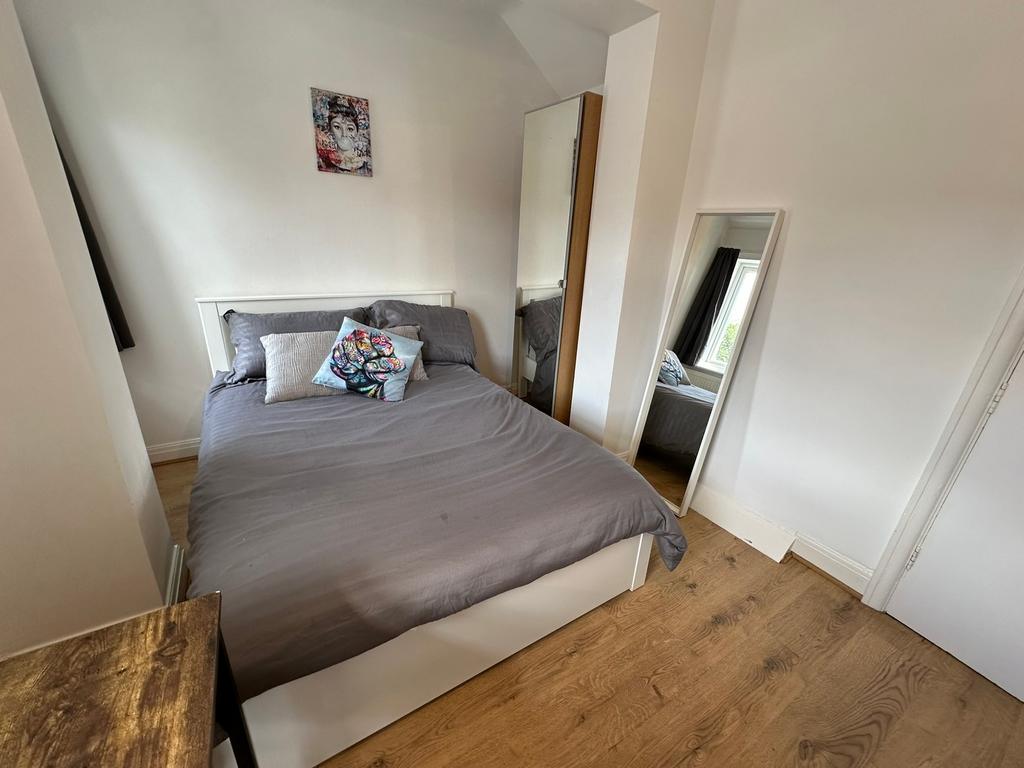 This inviting double bedroom features a comfort...