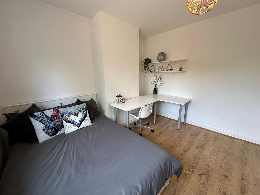 This inviting double bedroom features a cozy be...