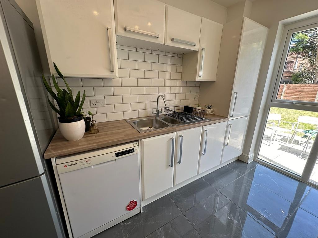 Bright and modern kitchen featuring sleek cabin...