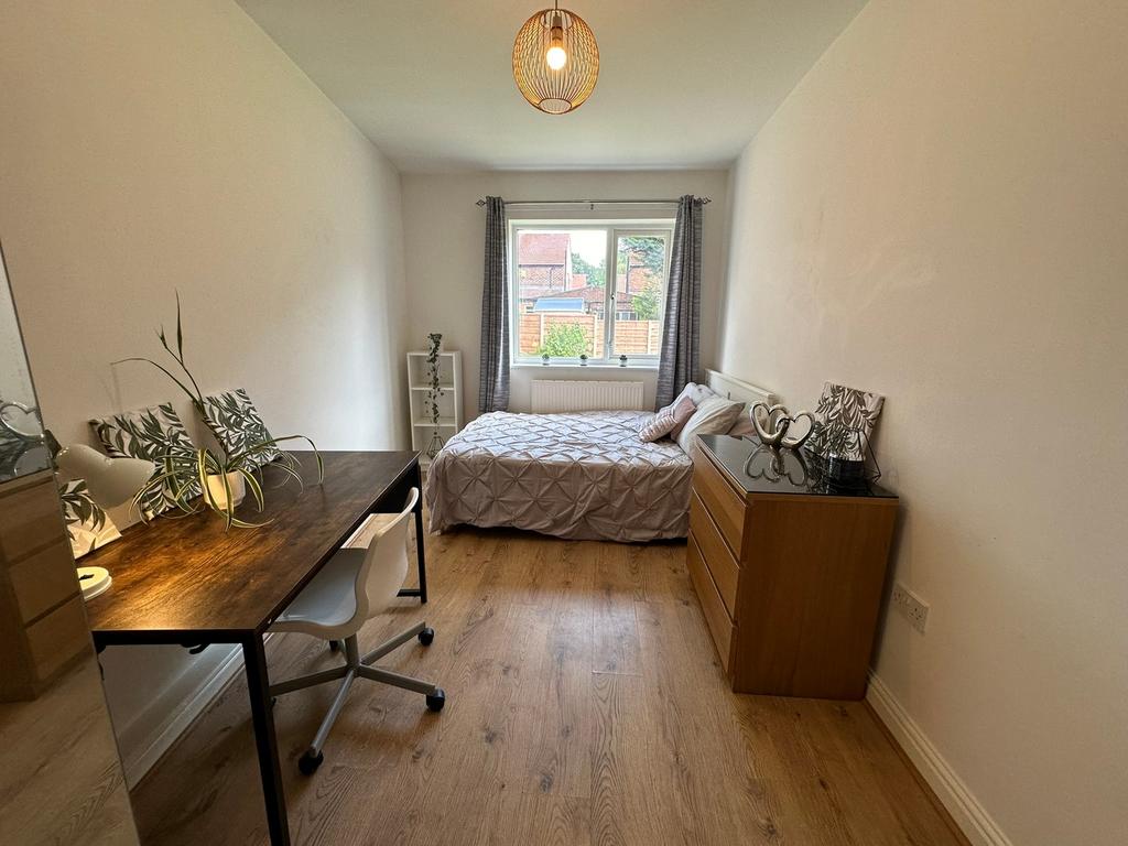 This inviting double bedroom features a comfort...
