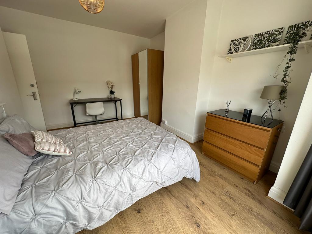 This spacious double bedroom features a comfort...