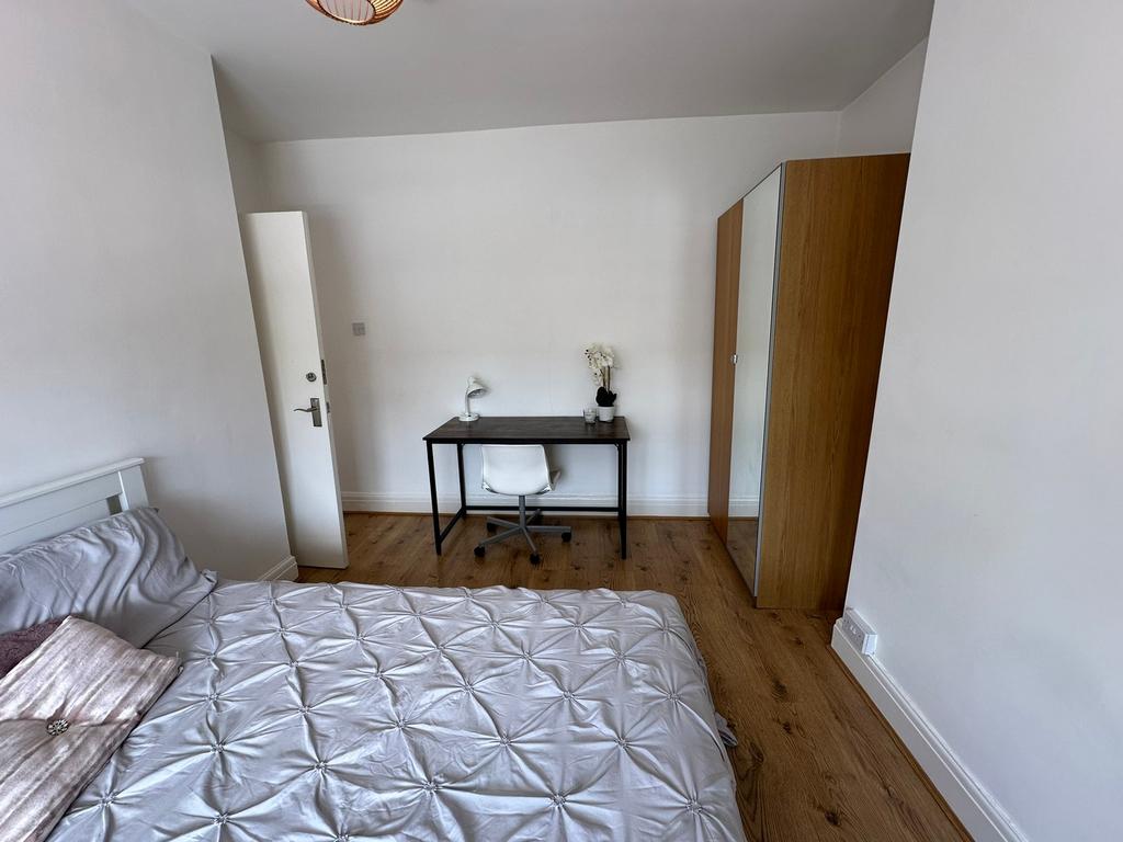 This inviting double bedroom features a comfort...