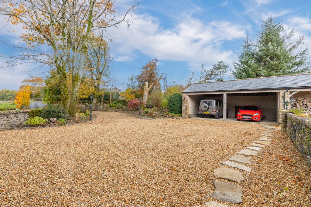 Garage with adjoining shed and log store