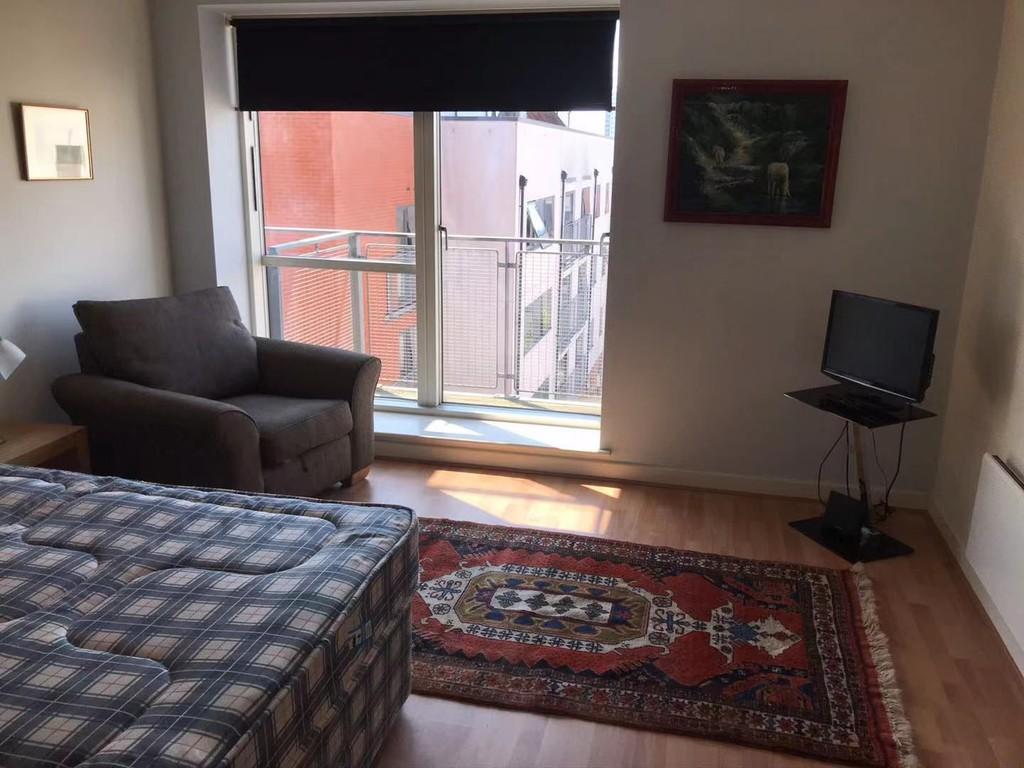 Bed with view of window and balcony