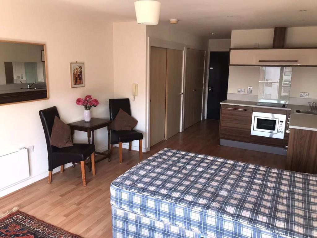 Bed with view of dining table and kitchen