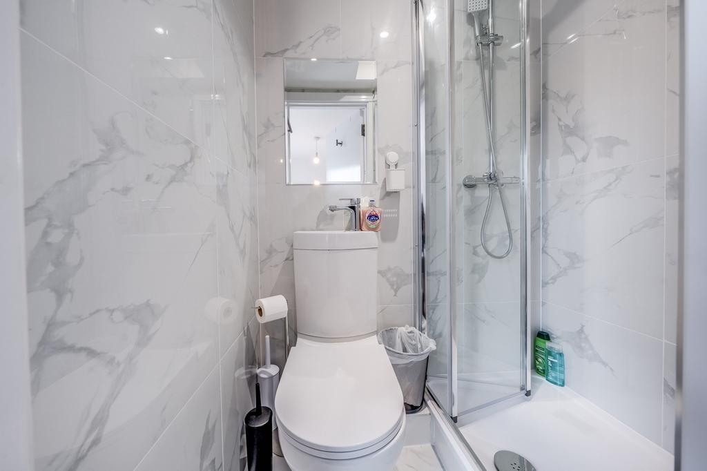 A modern bathroom featuring sleek marble tiles,...