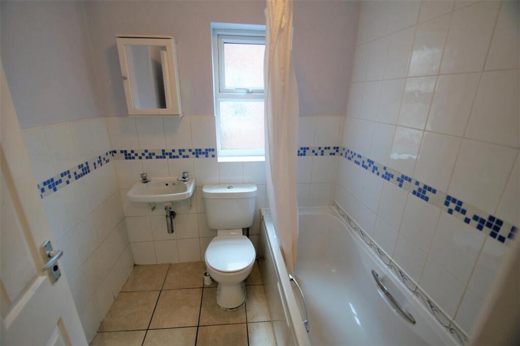 Bright and tidy bathroom featuring a clean bath...