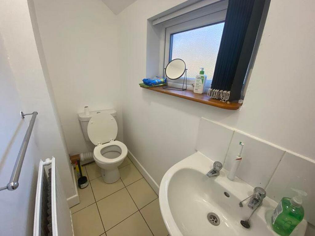 A tidy single toilet with natural light and mod...