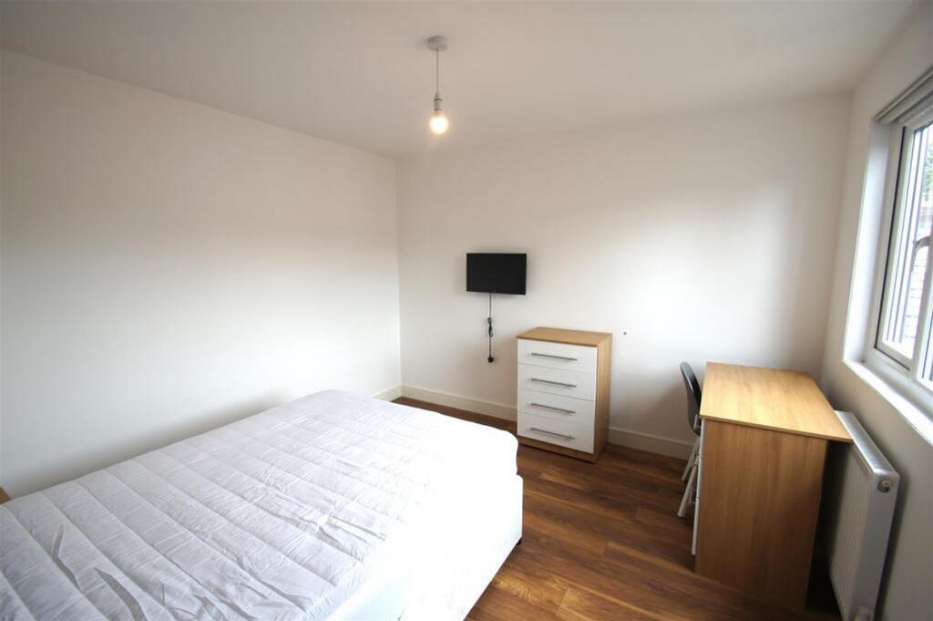 A spacious double bedroom featuring a comfortab...