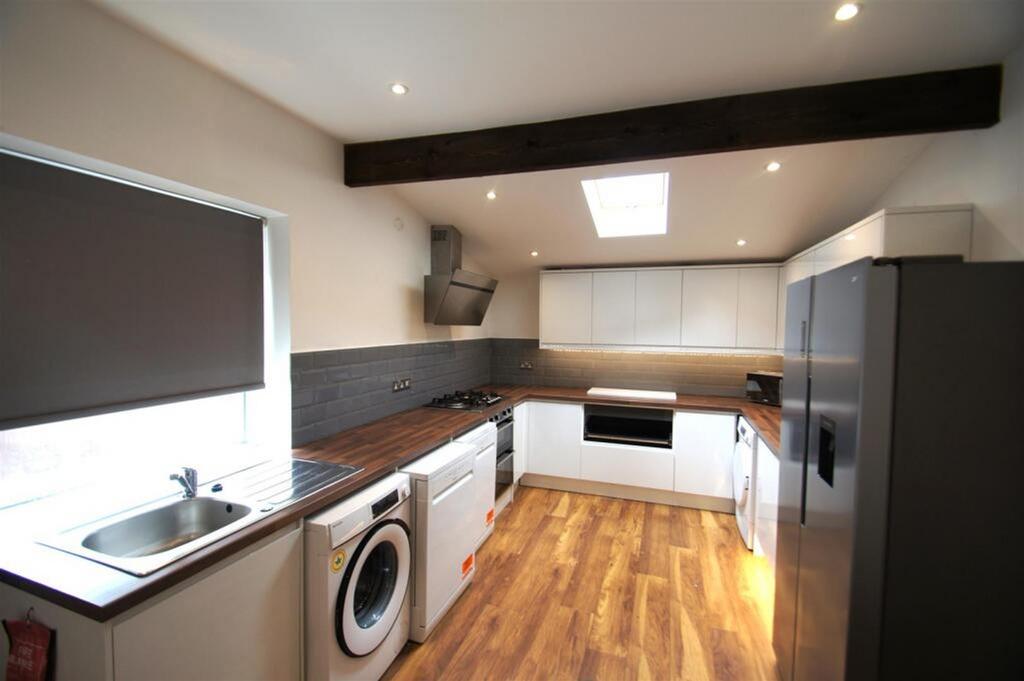 Modern kitchen featuring sleek cabinetry, ample...