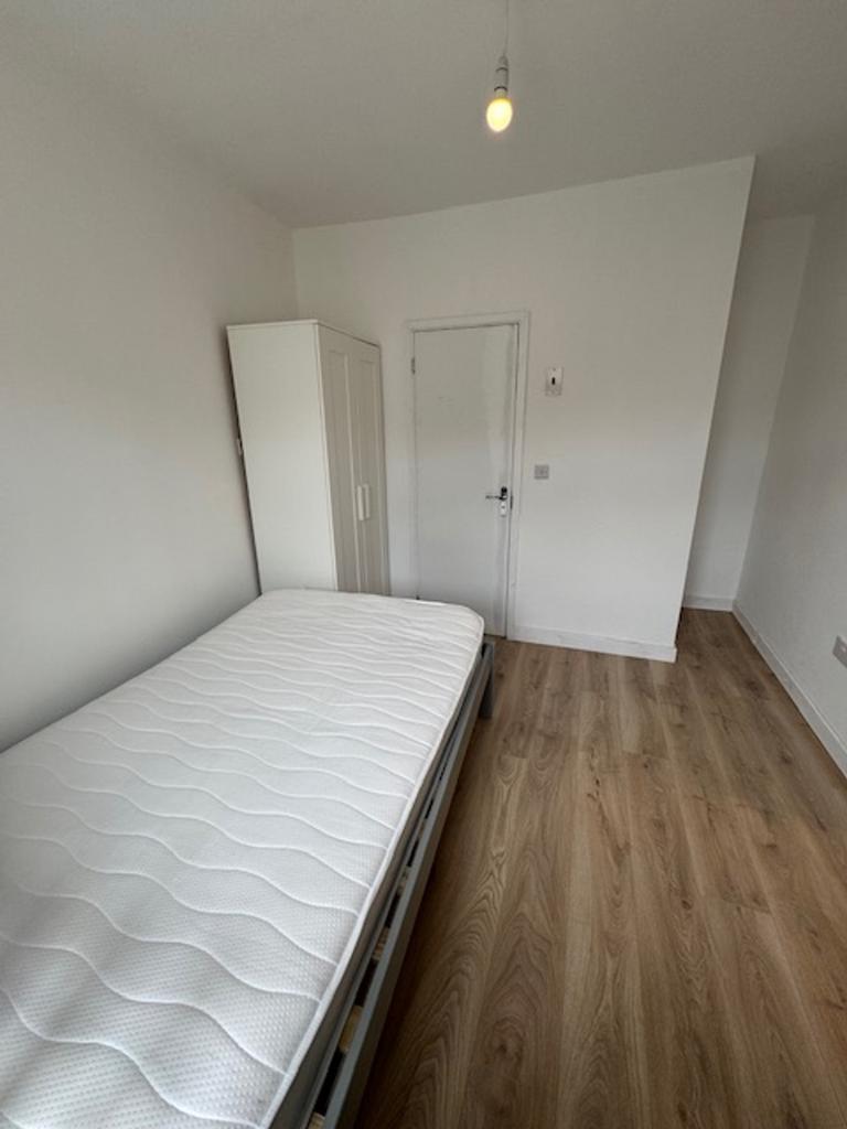 A bright and tidy single bedroom featuring a co...