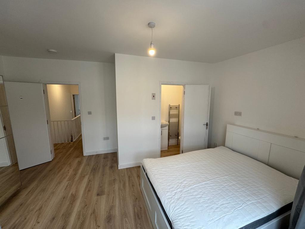 This spacious double bedroom features a comfort...
