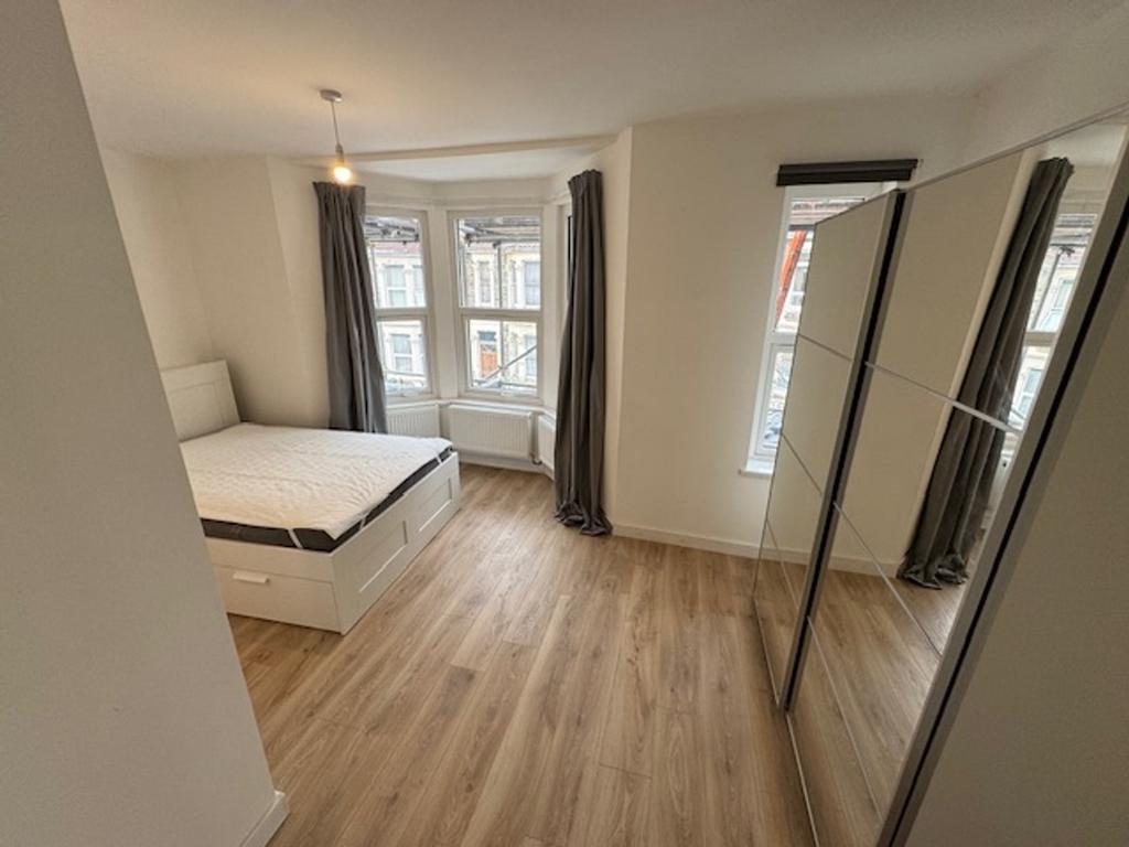 Spacious double bedroom featuring large windows...