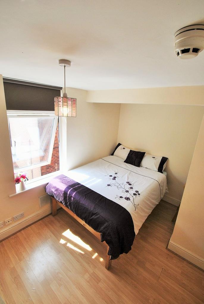 Cozy double bedroom featuring ample natural lig...