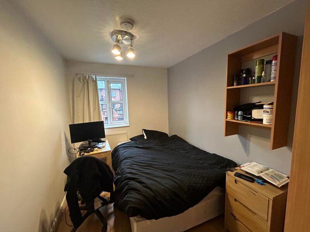 A cozy double bedroom with good lighting and a ...