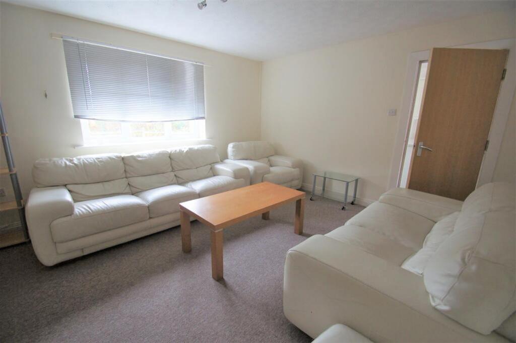 A bright and spacious living room featuring com...