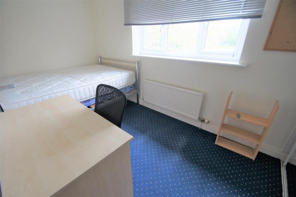 A cozy single bedroom featuring a comfortable b...