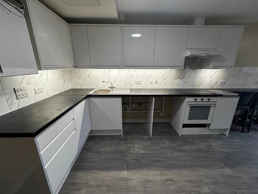 This modern kitchen features sleek cabinetry, a...