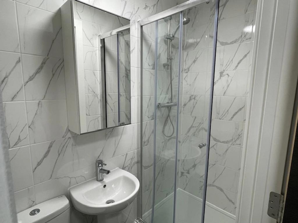 Modern bathroom featuring sleek marble tiles, a...