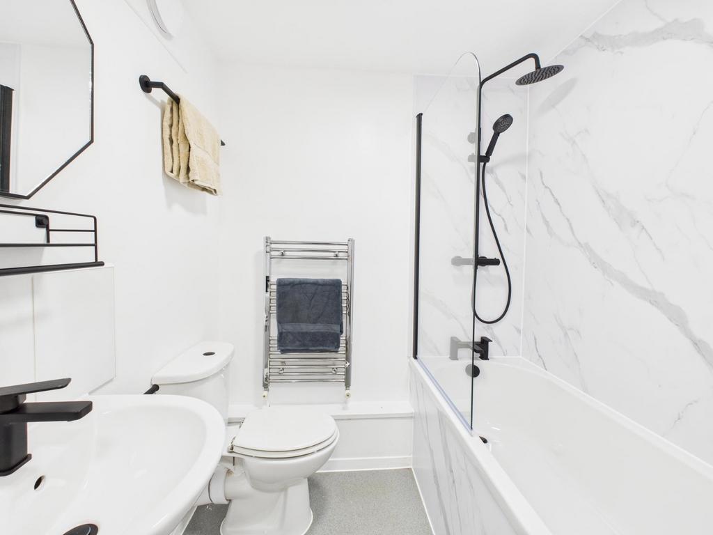 Bright modern bathroom with a white suite, marb...