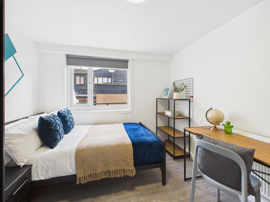 Bright, neatly styled double bedroom with a com...