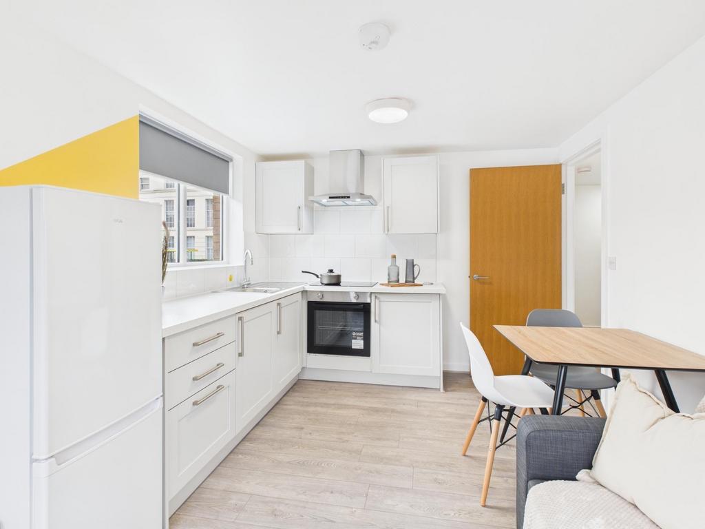 Bright modern kitchen with white cabinetry, int...