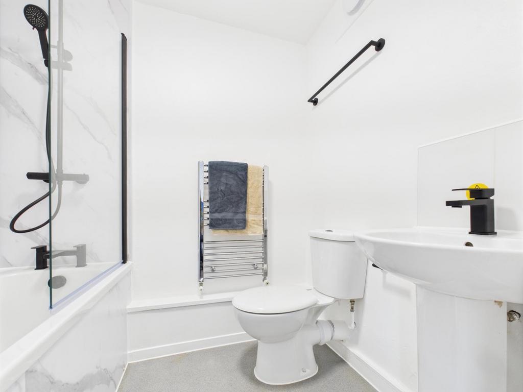 Bright, modern bathroom with a combined bath an...