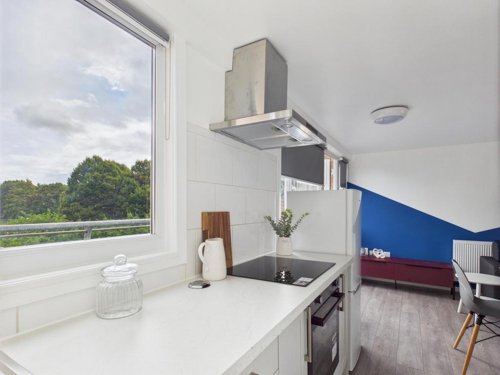 Bright modern kitchen with white countertops, i...